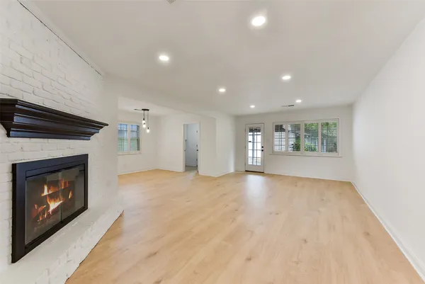 a view of an empty room with a fireplace and a window