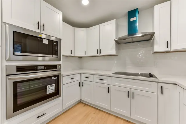 a kitchen with white cabinets stainless steel appliances and sink