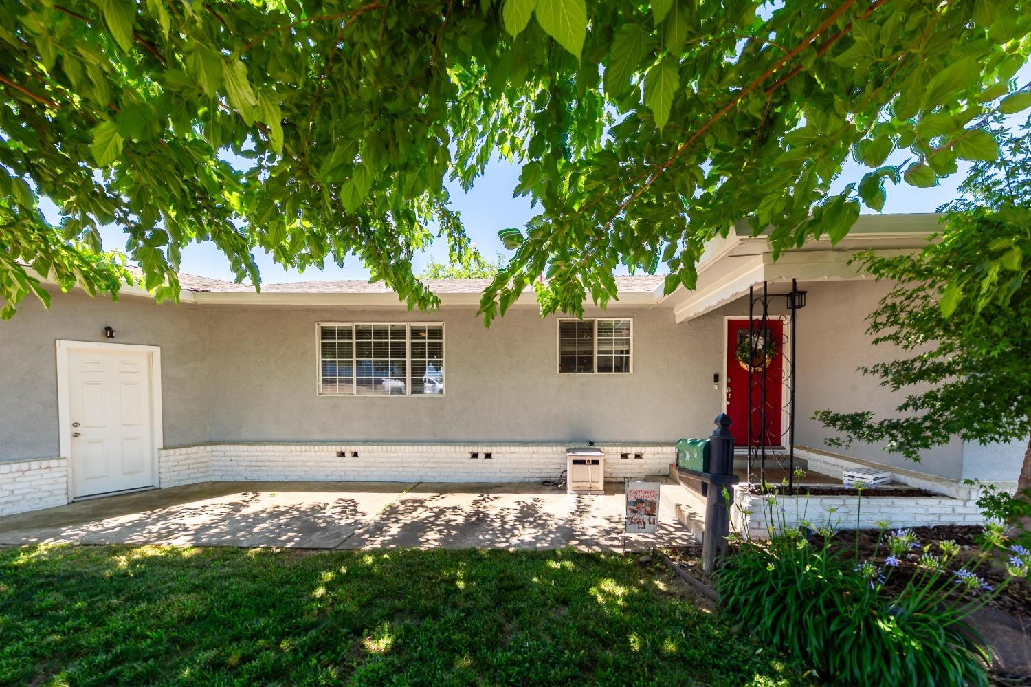 front view of house with a yard and potted plants