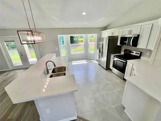 a kitchen with stainless steel appliances a stove sink and refrigerator