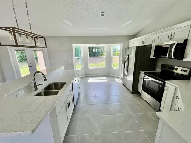 a kitchen with granite countertop a refrigerator and a sink