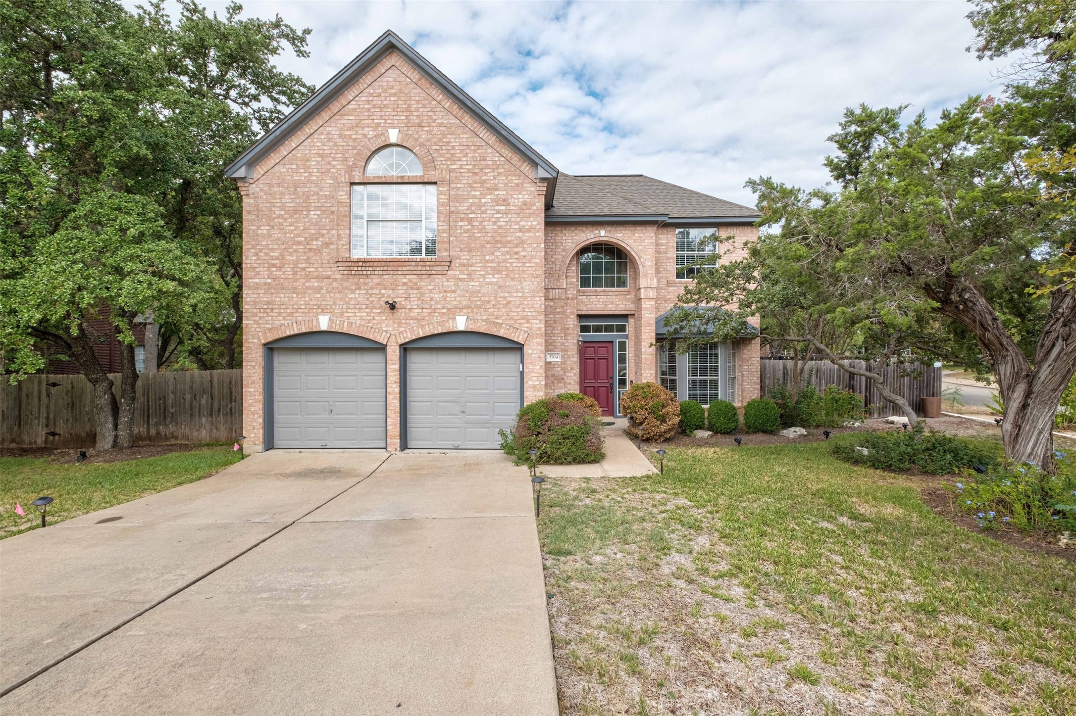3704 Runnels Court Austin, TX 78732 - Photo 1 of 30 View of front of property with brick siding, fence, and concrete driveway
