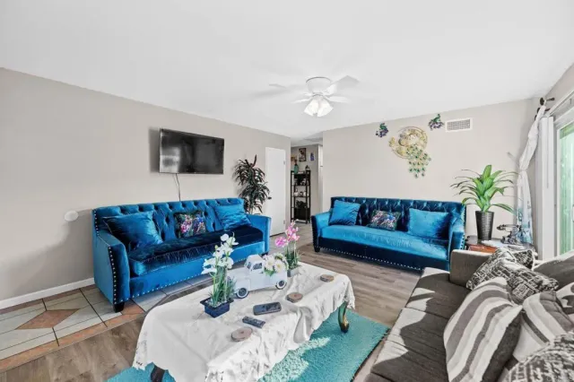 a living room with furniture ceiling fan and a rug