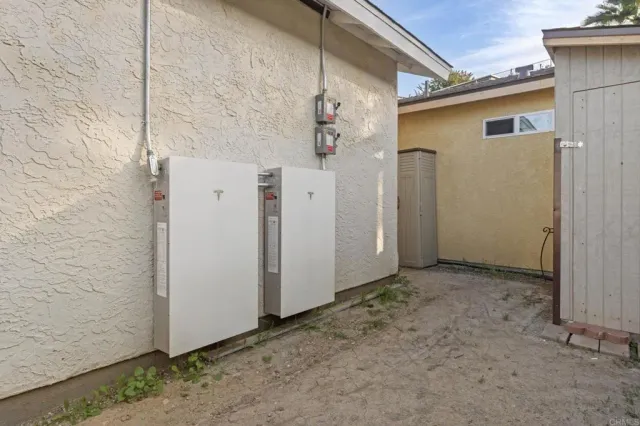 a view of a patio with table and chairs under an umbrella next to a road