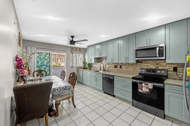 a kitchen with stainless steel appliances granite countertop a stove top oven a sink dishwasher and a refrigerator with wooden cabinets