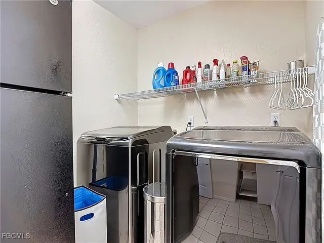 a utility room with stainless steel appliances a sink and a refrigerator