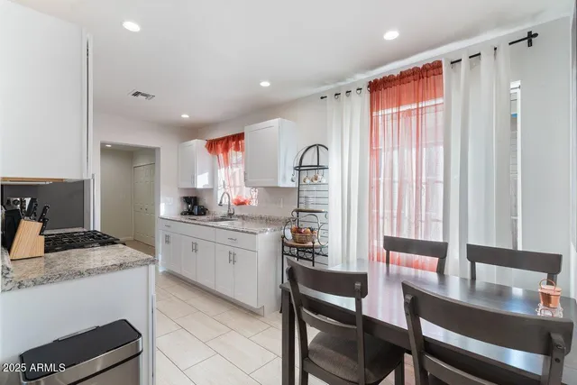 a kitchen with kitchen island granite countertop a table and chairs in it