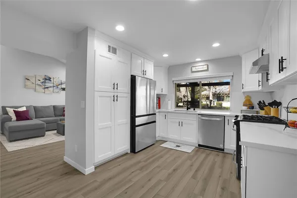 a kitchen with refrigerator a microwave and wooden floor