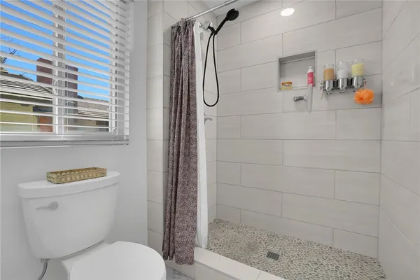 a bathroom with a shower a toilet and a shower