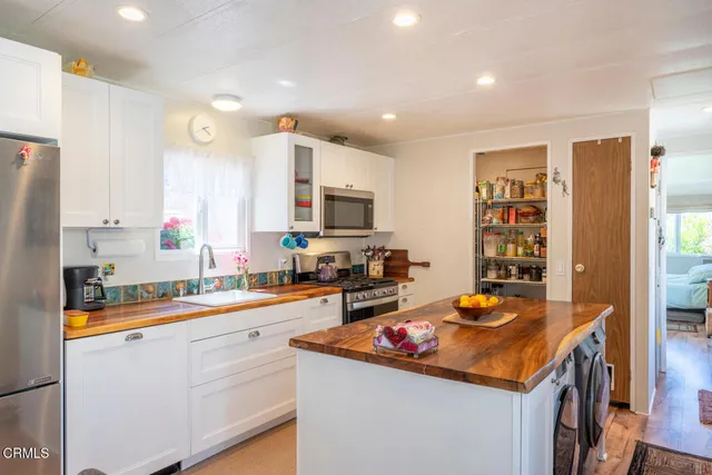 a kitchen with stainless steel appliances granite countertop a sink a stove and cabinets
