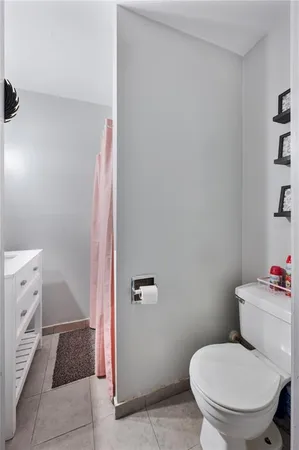 a white toilet sitting next to a bathroom sink and vanity
