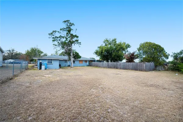 a palm tree sitting in front of a house with a yard