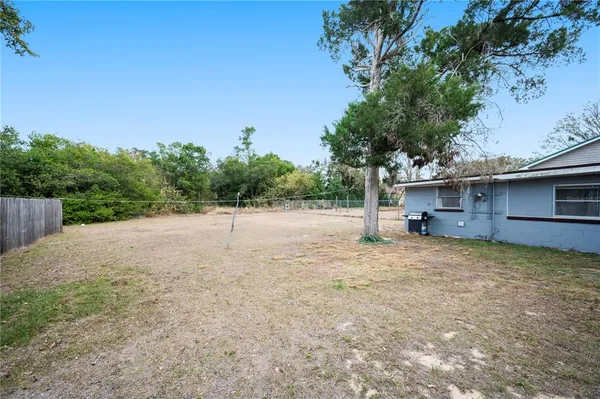 a view of a house with backyard and trees