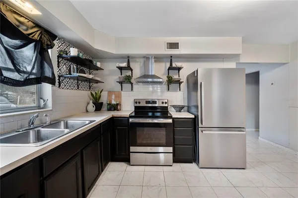 a kitchen with stainless steel appliances granite countertop a refrigerator and a sink