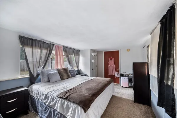 a bedroom with a bed and a refrigerator