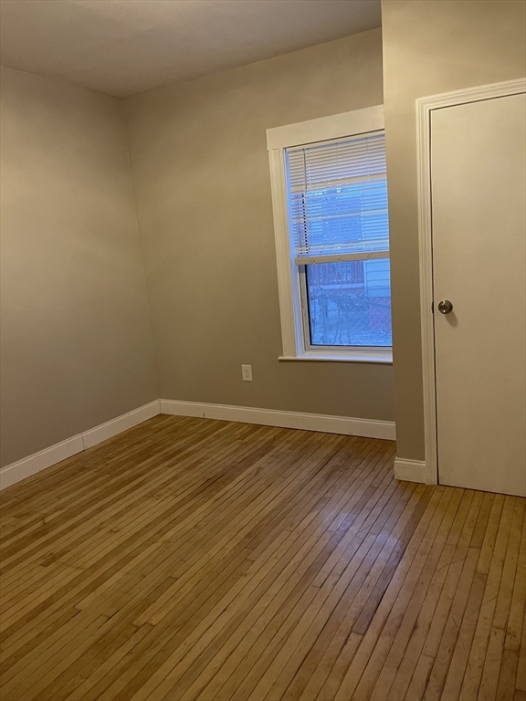 52 Houghton Street, Unit 1 Worcester, MA 01604 - Photo 15 of 15 a view of an empty room with wooden floor and a window