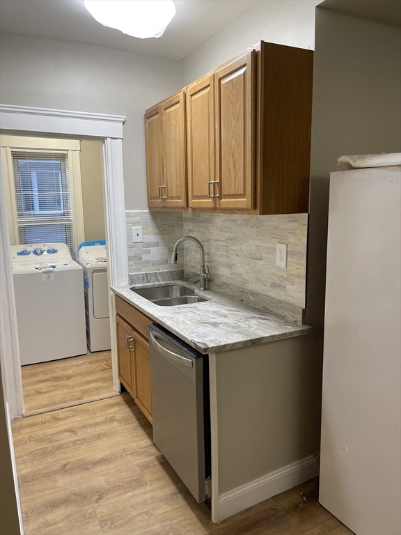 52 Houghton Street, Unit 1 Worcester, MA 01604 - Photo 5 of 15 a kitchen with stainless steel appliances granite countertop a sink and a refrigerator