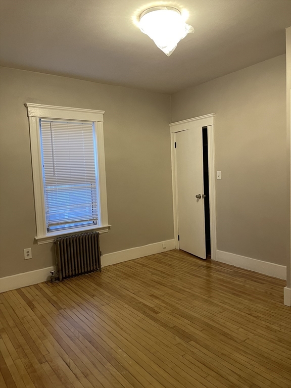 52 Houghton Street, Unit 1 Worcester, MA 01604 - Photo 10 of 15 an empty room with wooden floor and windows