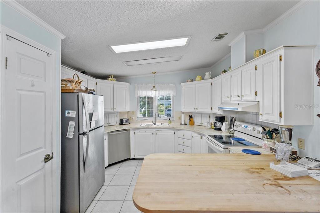 633 Starboard Avenue Edgewater, FL 32141 - Photo 9 of 57 a kitchen with stainless steel appliances granite countertop a refrigerator sink and white cabinets
