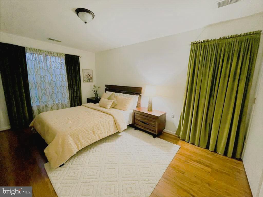 1043 Gardenview Loop, Unit 203 Woodbridge, VA 22191 - Photo 3 of 7 a bedroom with a bed and a mirror