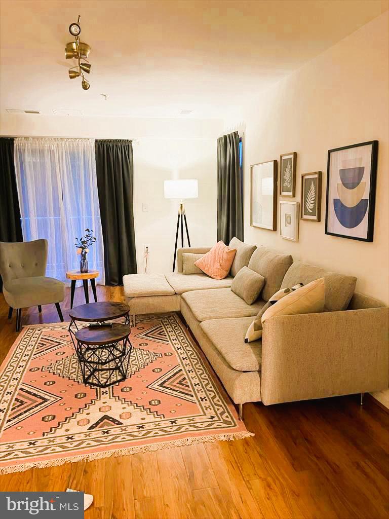 1043 Gardenview Loop, Unit 203 Woodbridge, VA 22191 - Photo 6 of 7 a living room with furniture and a flat screen tv