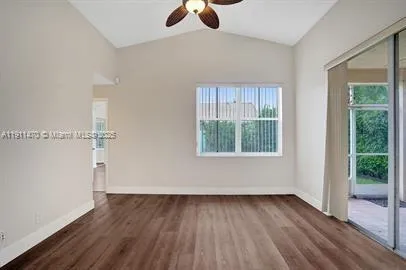 a view of a kitchen with wooden floor and a window