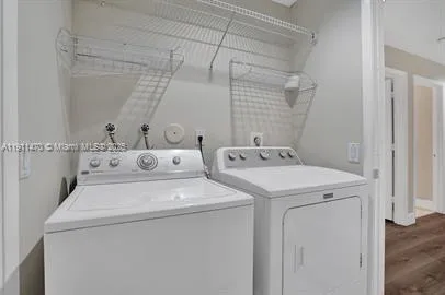 an empty room with wooden floor cabinet and windows