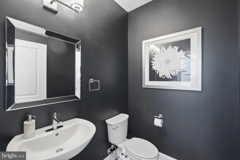 a bathroom with a toilet sink and mirror
