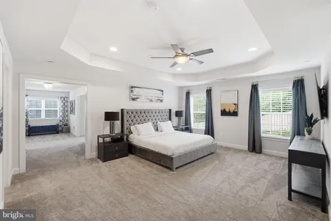 a spacious bedroom with a large bed and a chandelier