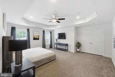 a spacious bedroom with a bed and a flat screen tv
