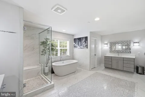 a bathroom with a tub sink and mirror