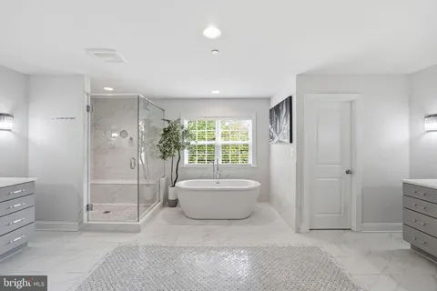 a spacious bathroom with a bathtub sink and mirror