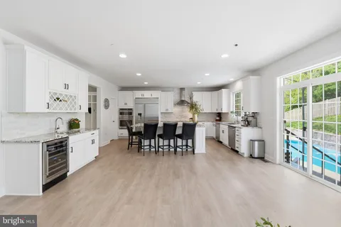 a large white kitchen with lots of counter space and stainless steel appliances