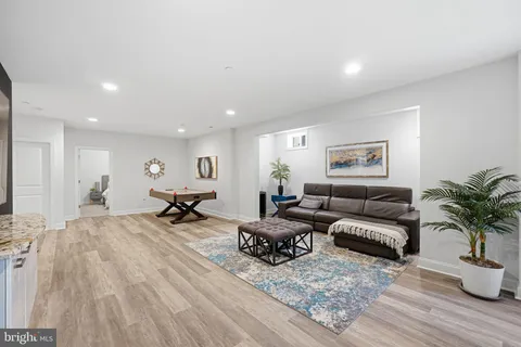 a living room with furniture a flat screen tv and a table