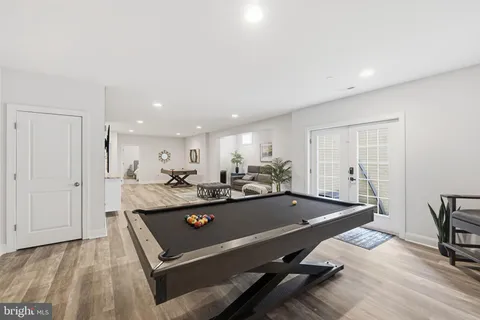 a living room with furniture a table and potted plants with wooden floor