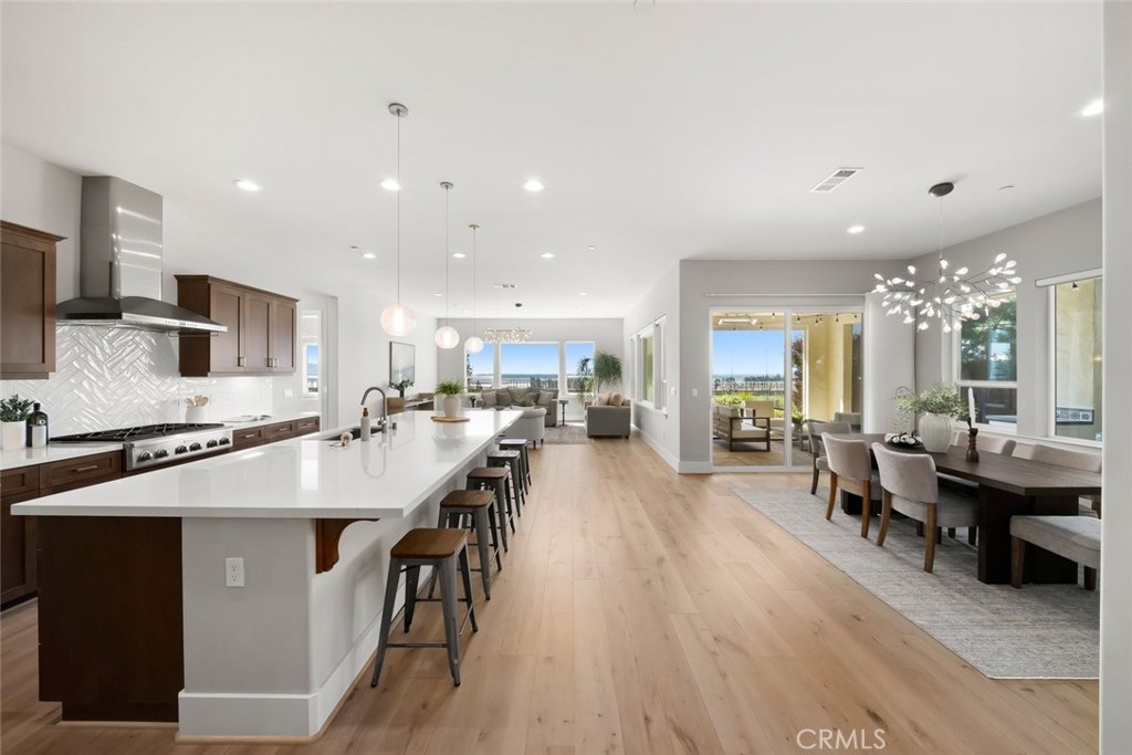 a large kitchen with kitchen island a island a sink a stove and wooden floor