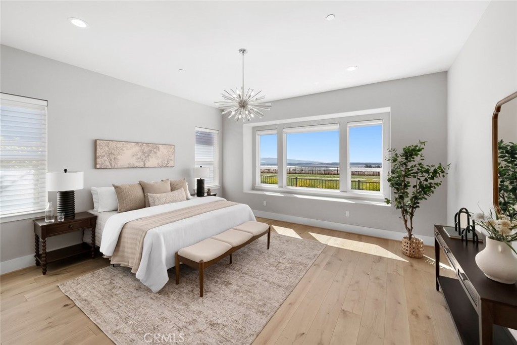 1590 Eucalyptus Road Nipomo, CA 93444 - Photo 24 of 75 a spacious bedroom with a large bed and a chandelier