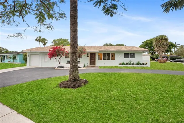 a front view of a house with a garden and yard