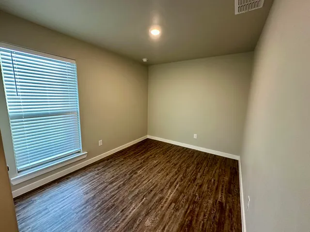 a view of a room with wooden floor and window