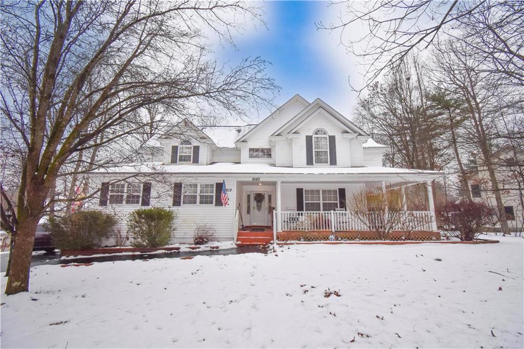 front view of a house with a yard covered in snow