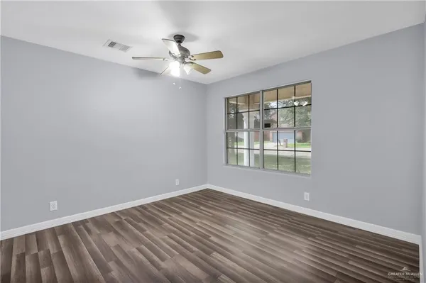 a view of wooden floor in an empty room with a window