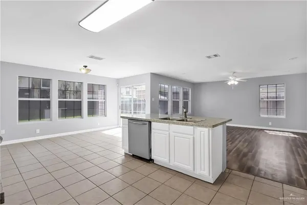 a kitchen with granite countertop a refrigerator and a stove top oven