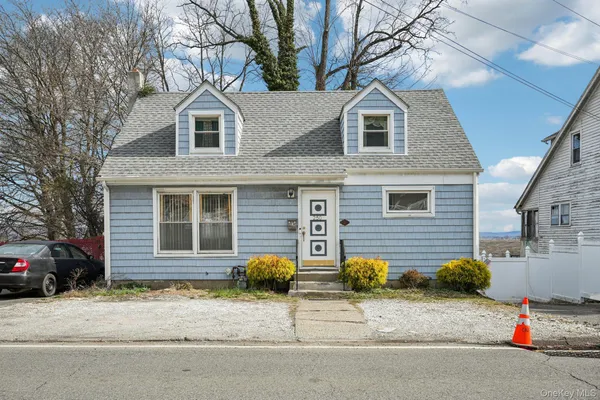 a view of a house with a yard and large tree