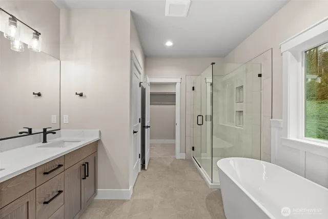 a spacious bathroom with a tub sink shower and mirror