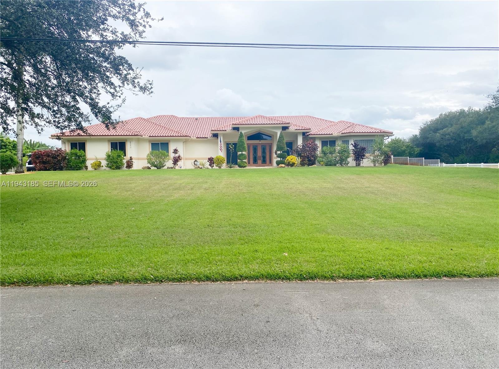 6550 Southwest 183rd Way Southwest Ranches, FL 33331 - Photo 2 of 24 a front view of a house with a garden and a yard