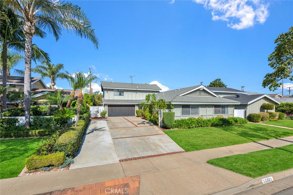 13561 Dean Street Tustin, CA 92780 - Photo 1 of 1 a front view of a house with a yard and potted plants