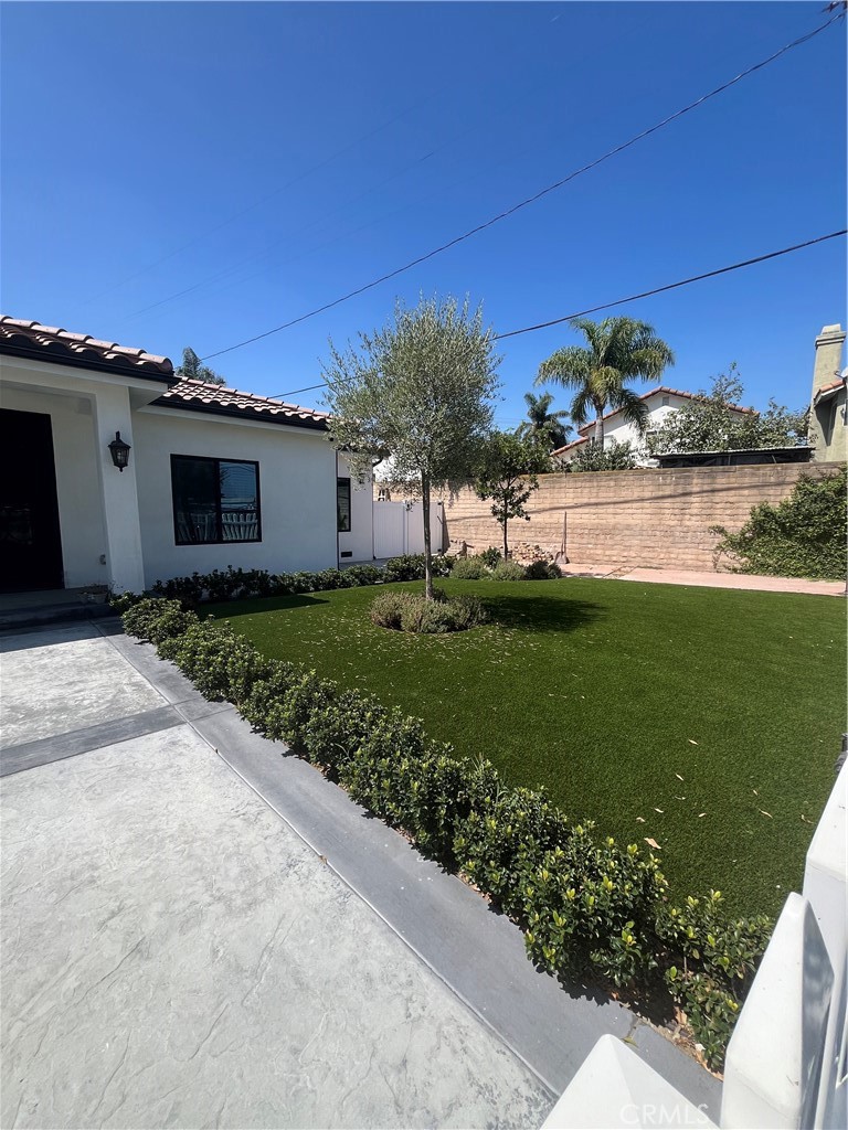 7274 Century Paramount, CA 90723 - Photo 3 of 11 a front view of a house with garden