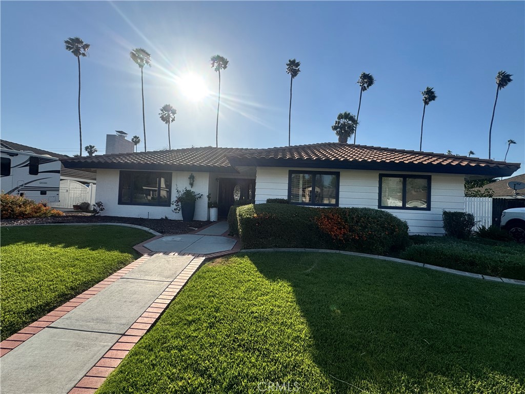 4967 Chapala Drive Riverside, CA 92507 - Photo 1 of 34 a front view of a house with a garden and yard