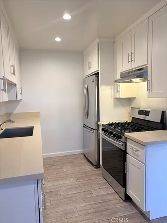 a kitchen with a sink a stove and a refrigerator