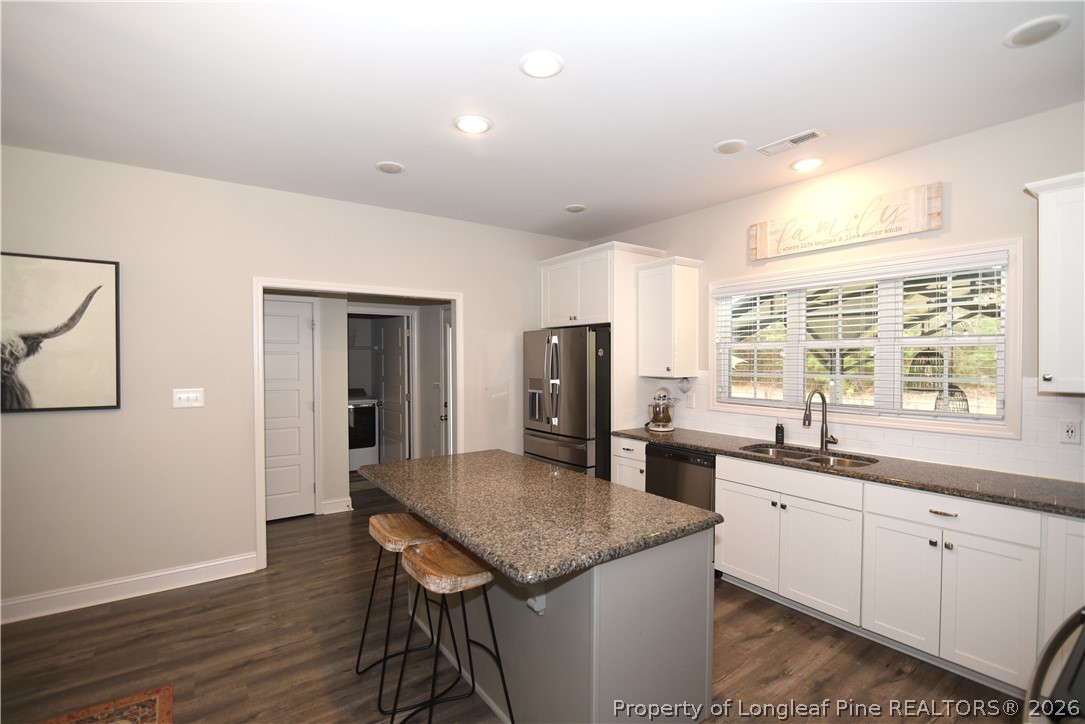 1843 Meadow Road Lumberton, NC 28358 - Photo 12 of 35 a kitchen with stainless steel appliances granite countertop hardwood floor sink stove dining table and chairs